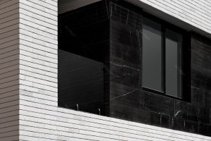 نمای سفید آجرب ساختمان با سنگ سیاه و پنجره