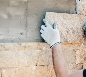 construction worker installing stone on architectural facade of new picture id686912370